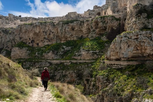 A woman hiking through the canyon of Matera, Southern Italy