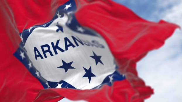 Arkansas state flag waving in the wind on a clear day. Red field with blue-bordered white diamond. 29 stars and ARKANSAS in blue. 3d illustration render. Selective focus. Fluttering fabric.
