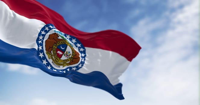 Missouri state flag waving on a clear day. Red, white, blue horizontal stripes with Great Seal of Missouri in center. 3d illustration render. Textured background. Selective focus. Fluttering textile