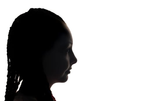 The girl portrait profile in silhouette shadow on studio. White background. Horizontally.