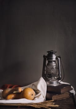 Autumn still life with vintage lantern and pumpkin vegetable on rustic wooden table. Thanksgiving and halloween holiday design concept.