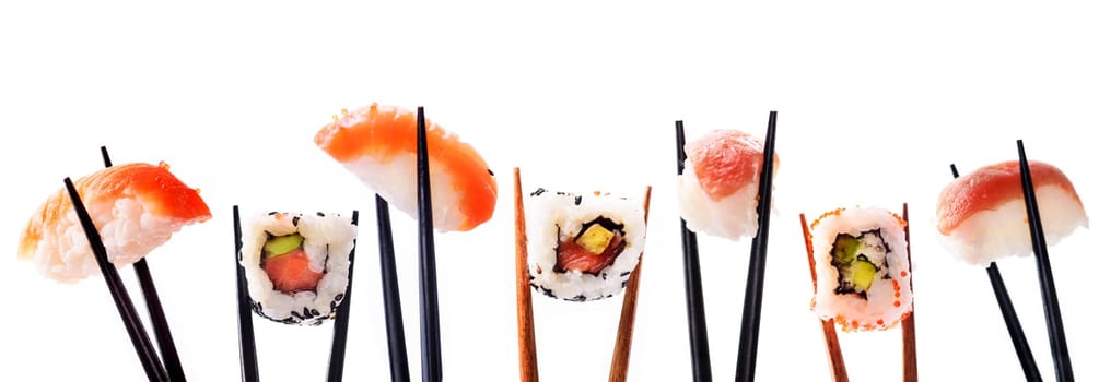 Creative sushi rolls on bamboo chopstick isolated on white background. Japanese luxury cuisine menu. Asian restaurant menu design. Mix of sushi pieces with salmon, tuna fish, avocado and rice.