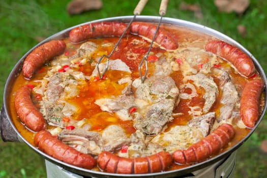 Baked sausages in traditional Croatian dish kotlovina.