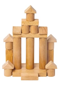 Wooden isolated house. Wooden toy castle constructed of cubes, cylinders, triangles and other shapes made of beech wood. Wooden toy blocks. Macro.