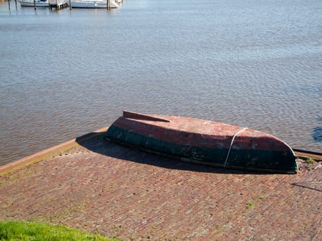 Rowing lifeboat parked upside down on a brick terrace on the dike in Harlesiel Germany.