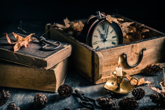 Vintage still life with  antique  books, clock and candle. Halloween and occult concept.