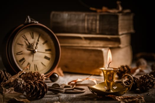 Vintage still life with  antique  books, clock and candle. Halloween and occult concept.