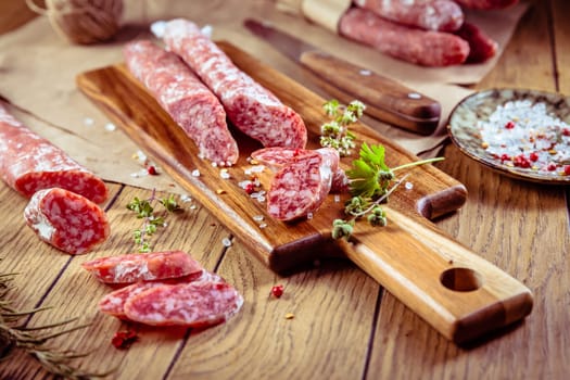 Traditional Spanish fuet on wooden background. Dry cured pork sausages with delicate taste.