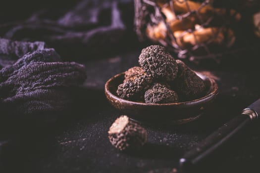 Expensive black truffles gourmet mushrooms  on kitchen table