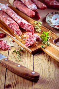 Traditional Spanish fuet on wooden background. Dry cured pork sausages with delicate taste.