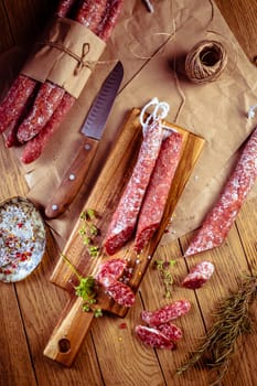 Traditional Spanish fuet on wooden background. Dry cured pork sausages with delicate taste.