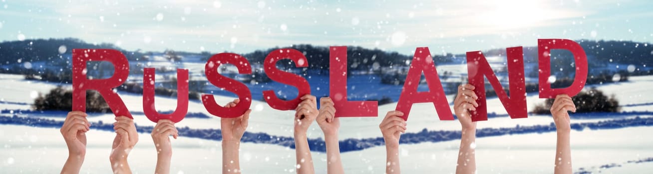 People Or Persons Hands Building German Word Russland Means Russia. White Winter Background With Snowflakes And Snowy Landscape.