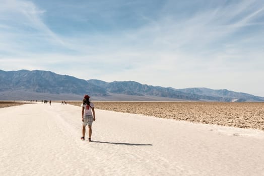 A lonely person hiking through famous Badwater Basin in the Death Valley, USA