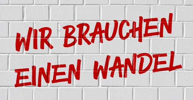 Graffiti on a brick wall - We need a change in german