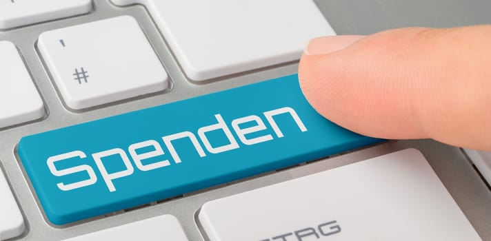 A keyboard with a blue labeled button - Donations in german - Spenden