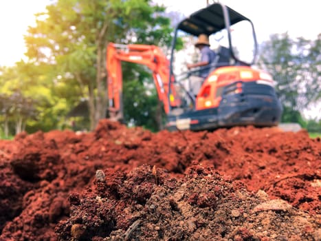 Soil close up blurred backhoe to renovate the site in preparation for pouring the concrete slab. Construction concept
