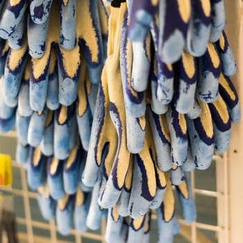 Rubberized grey work gloves hanging on a wall. Part of work-wear and protection equipment.
