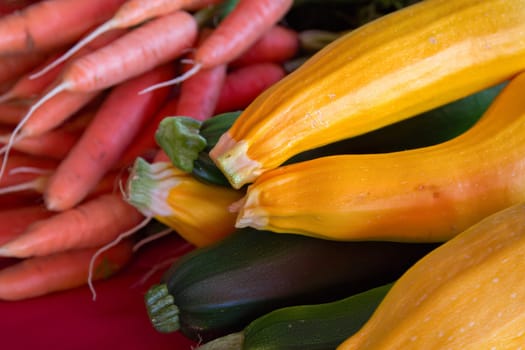 close-up of vegetables, yellow squash, carrots and zucchini displayed at the farm market organic agriculture harvest