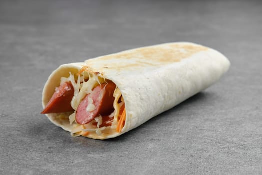 Flatbread rolled with with thin sausage, pickled carrot, cabbage and melted cheese