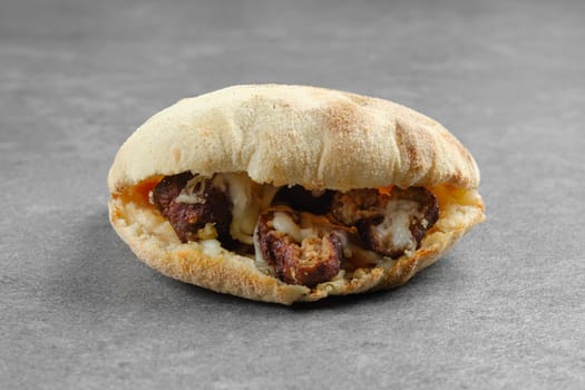 Pita bread with beef or lamb meatballs, pickled onion and melted cheese