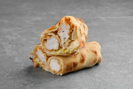 Chicken fillet rolled and baked in dough with cabbage, tomato and cheese cut on half