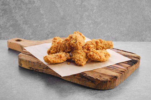 Deep fried chicken wings in breading on parchment paper