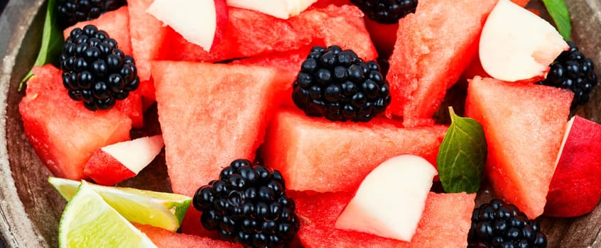 Vitamin salad of watermelon, blackberry and peach. Summer fruit diet salad. Close up.