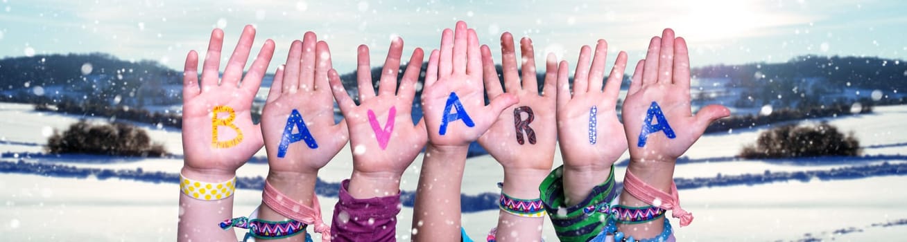 Children Hands Building Colorful English Word Bavaria. White Winter Background With Snowflakes And Snowy Landscape.