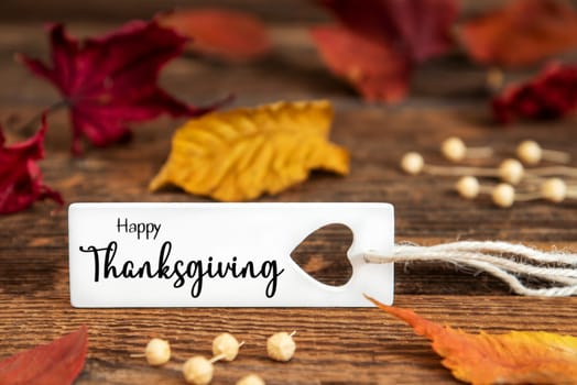 Autumn or Fall Background with Label with English Text Happy Thanksgiving, Colorful Autumn Leaves, Seasonal Background with Quote