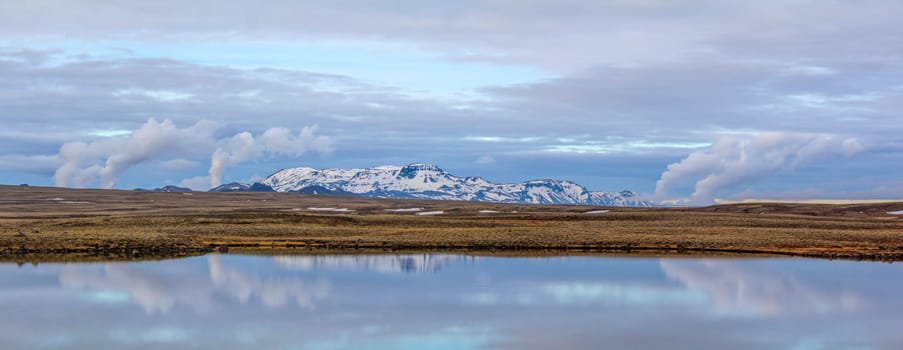 Panoramia of a mountain range and steam of geothermal power plants, Iceland