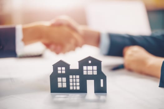 Handshake between two people concluding a contract for the sale of housing. Concept of the real estate and buying new apartment.