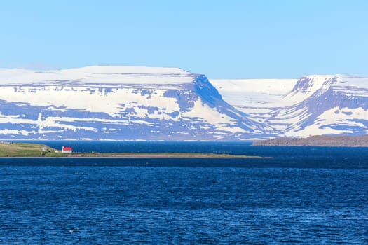 View to the next coast, church with red roof in between, Iceland