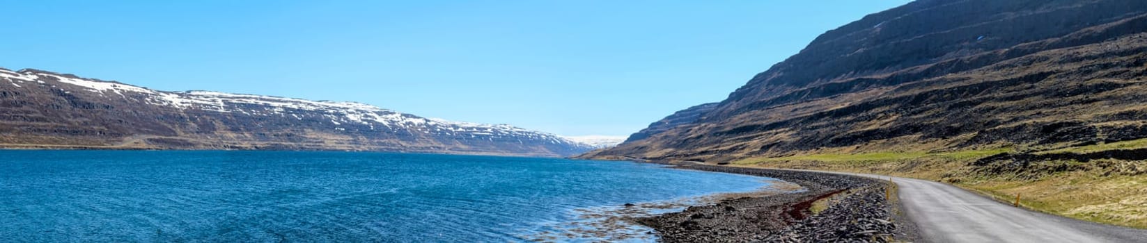 Panoramic view of a gravelled road at a fjord, Westfjords of Iceland