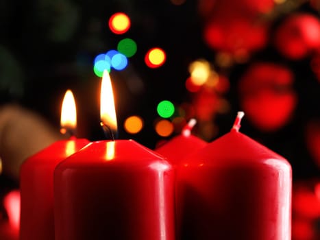 Second Advent candle burning, red Advent candles with decoration in a dark room, space for text or image