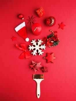 Paintbrush with Christmas decoration on a red background, greetings card or holiday background