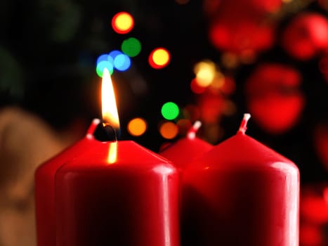 First Advent candle burning with Christmas decoration in a dark room, seasonal or holiday background