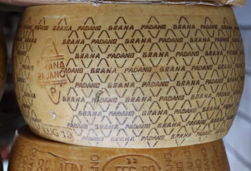Cremona, Italy - September 7, 2022: Whole wheels of Parmigiano Reggiano cheese sold at a street stall during the farmers market in Cremona, Lombardy, Italy