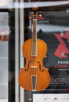 Cremona, Italy - September 7, 2022: Store Window of a Luthier's shop in Cremona. Handmade Violins on Display.