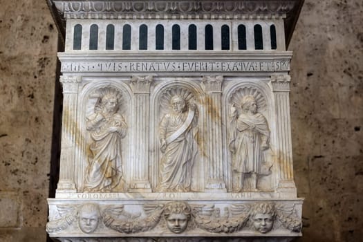 Massa Marittima, Italy - Sept 11, 2022:  Monumental baptismal font, with a rectangular bath surmounted by a small temple. The baptistery dates from 1267. Cathedral of Saint Cerbonius in Massa Marittima. Italy