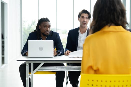 Job interview concept. Diverse hr team doing job interview with a woman in business office. Human resources team interviewing a potential job candidate. Hiring, employment, and recruitment concept.