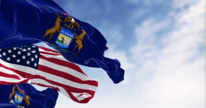 Flags of Michigan and the United States waving in the wind on a clear day. Patriotism and identity concept. 3d illustration render. Rippled fabric. Selective focus
