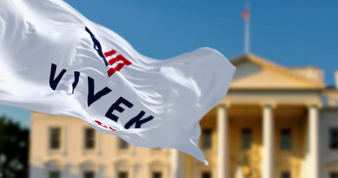 Washington D.C., US, June 21 2023: Flag with Vivek Ramaswamy 2024 presidential election campaign flag waving in front a blurred White House. Illustrative editorial 3d illustration render.