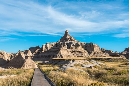 A pathway in Badlands National Park leading to jagged hills, South Dakota, USA