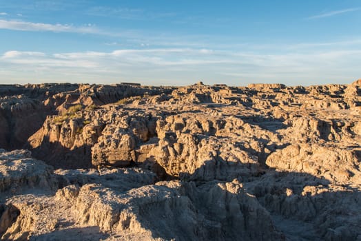 Jagged sandstone mountains illuminated from the sun in Badlands National Park, USA