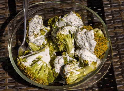 Healthy diet. Steamed broccoli topped with yogurt sauce