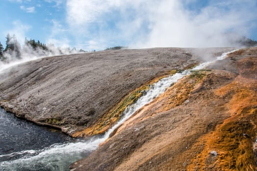 A little stream of hot water flowing in a natural pool, Yellowstone NP, USA