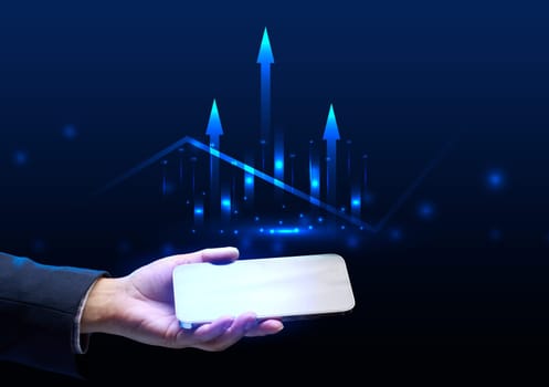 A woman's hand holds a smartphone and a holographic graph with growing indicators. Profitable business