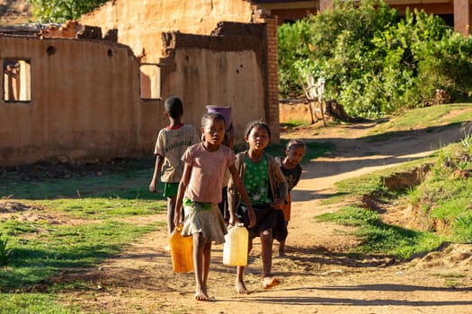 Lakanga, Andringitra mountain, Madagascar - November 15, 2022: , Madagascar - November 15, 2022: Malagasy girls from Lakanga village delivering water for cooking in the morning.