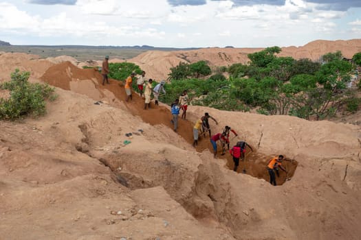 Ilakaka, Madagascar - November 24th 2022 - Working in tandem, miners united their effort, shoveling earth and meticulously seeking out sapphire gems, synchronized effort reminiscent of linked chains.