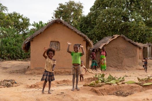 Ilakaka, Madagascar - November 24, 2022: Curious group of children looking at a tourist near the gem mining fields in Ilakaka. The children are descendants of local miners and live in simple village.